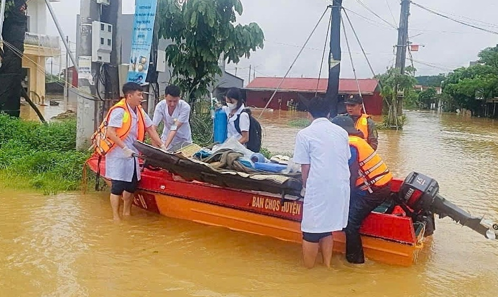 Bác sĩ vật lộn với nước lũ để ép tim bệnh nhân trên ca nô cứu hộ